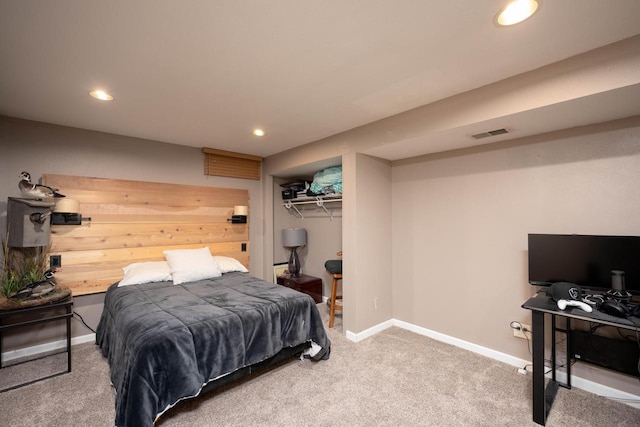 carpeted bedroom featuring a walk in closet and a closet