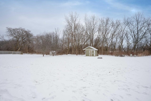 yard layered in snow with a storage shed