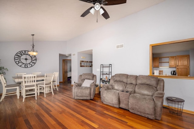 living room featuring dark hardwood / wood-style floors, ceiling fan, and vaulted ceiling