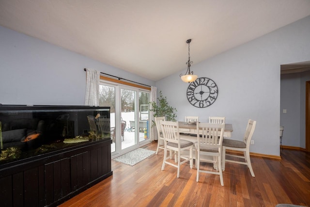 dining room featuring vaulted ceiling and hardwood / wood-style flooring