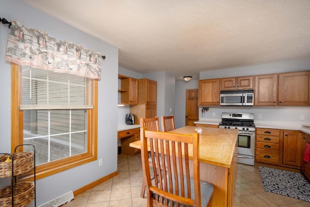 kitchen with a textured ceiling and stainless steel appliances