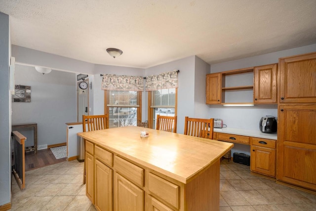 kitchen with a textured ceiling, butcher block countertops, and a kitchen island