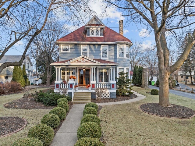 victorian home with a porch and a front lawn