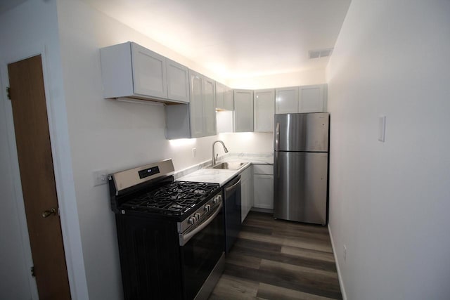 kitchen with white cabinets, dark hardwood / wood-style floors, sink, and appliances with stainless steel finishes