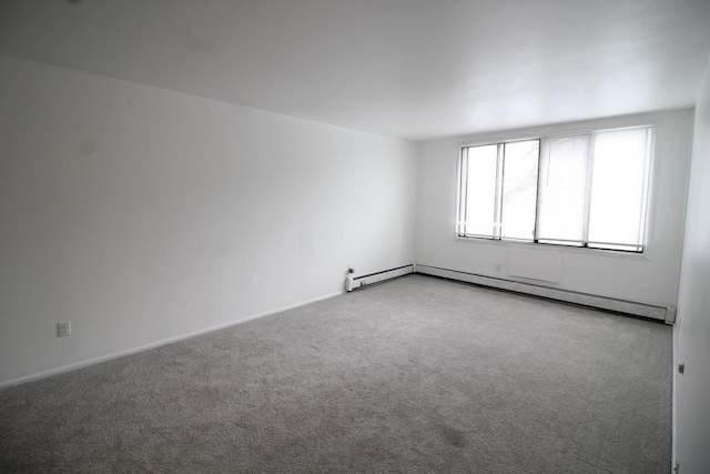 carpeted empty room featuring baseboard heating