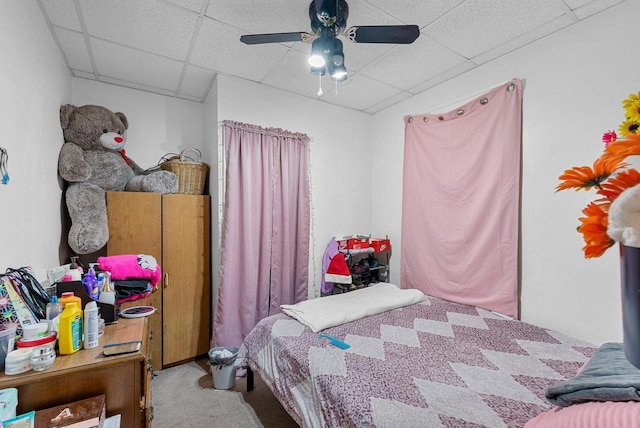 bedroom with carpet flooring, ceiling fan, and a drop ceiling