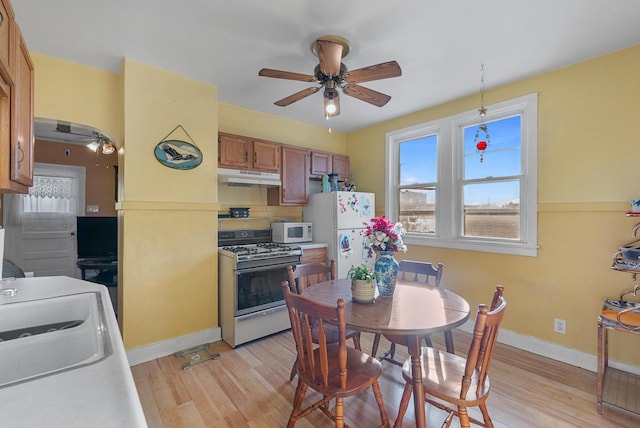 kitchen with ceiling fan, light wood-type flooring, white appliances, and sink