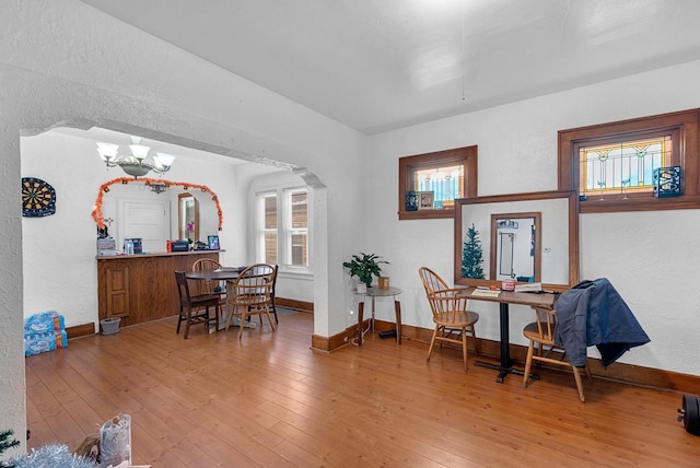 living area with a notable chandelier, plenty of natural light, and wood-type flooring