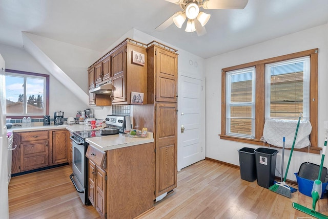 kitchen with light hardwood / wood-style flooring, ceiling fan, and stainless steel range with electric cooktop