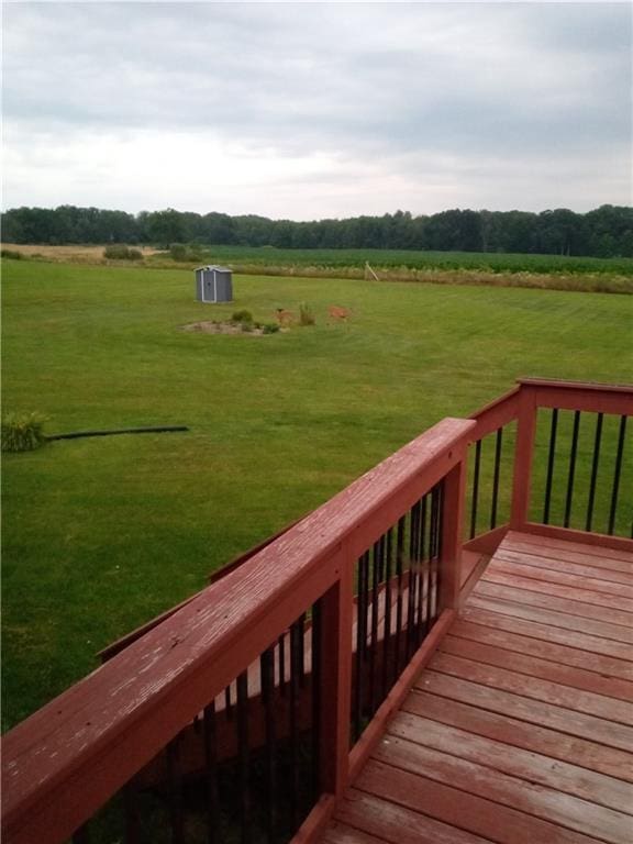 deck with a yard and a rural view