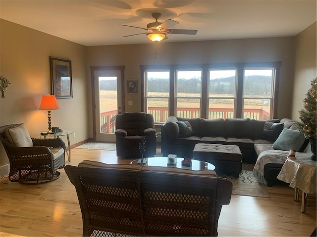 living room with ceiling fan, a healthy amount of sunlight, and light hardwood / wood-style flooring