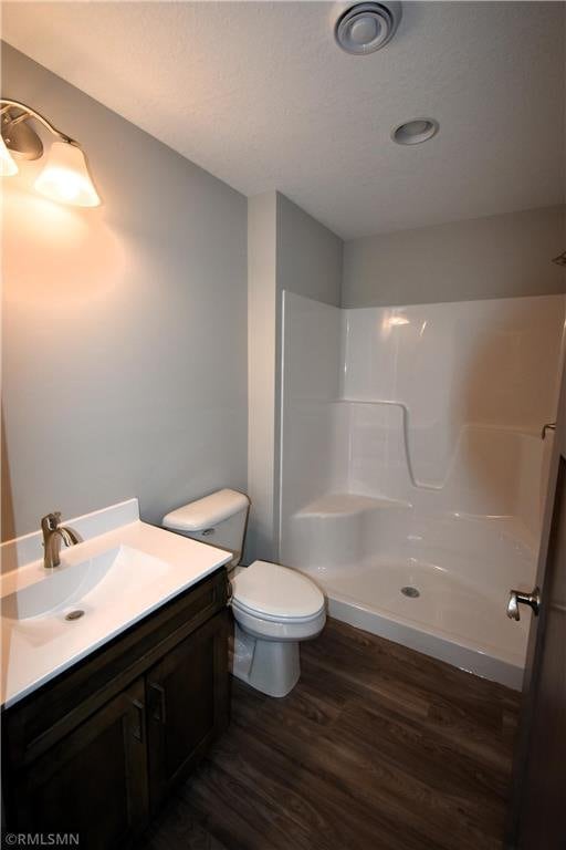 101 Nelson St, Elmwood, WI 54740 - bathroom with toilet, vanity, wood-type flooring, and walk in shower