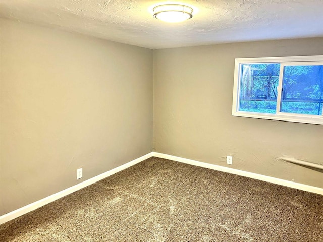 carpeted spare room with a textured ceiling