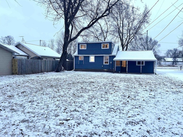 view of snow covered back of property