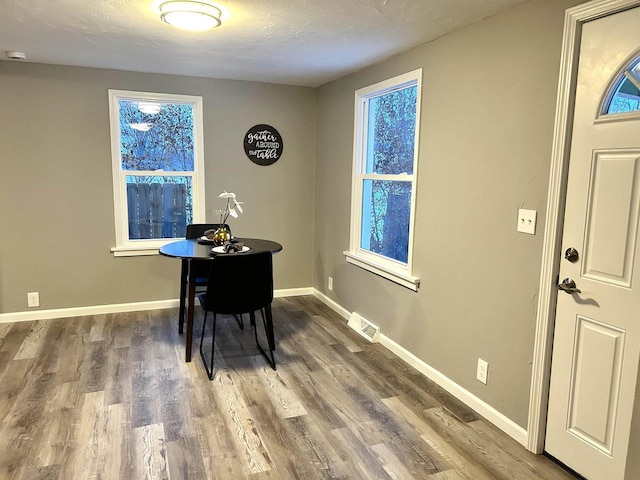 dining space featuring hardwood / wood-style floors and a textured ceiling