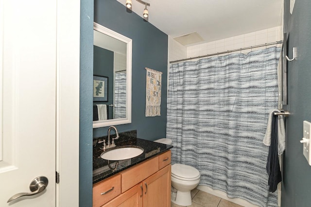 bathroom with tile patterned flooring, vanity, toilet, and walk in shower