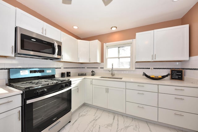 kitchen featuring sink, white cabinetry, stainless steel appliances, and tasteful backsplash