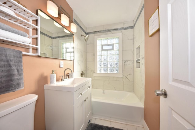 full bathroom featuring tiled shower / bath combo, toilet, and vanity