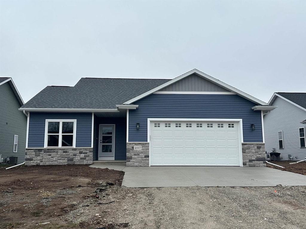 craftsman-style home featuring a garage and cooling unit