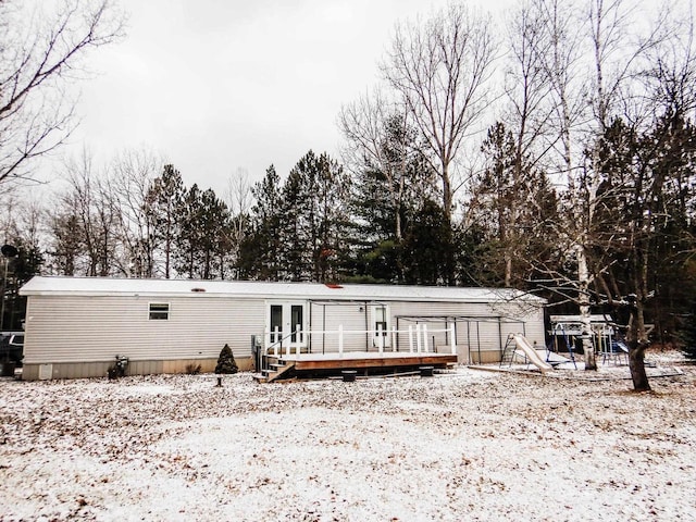 snow covered property featuring french doors and a wooden deck