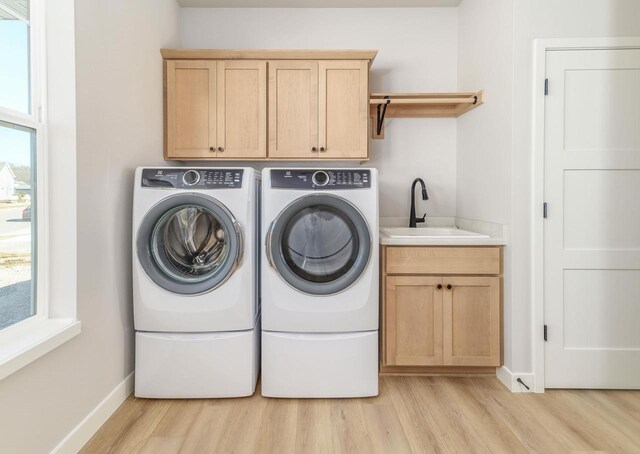 3620 Angelus Way, Cross Plains, WI 53528 - washroom featuring a sink, washing machine and clothes dryer, baseboards, light wood-style floors, and cabinet space