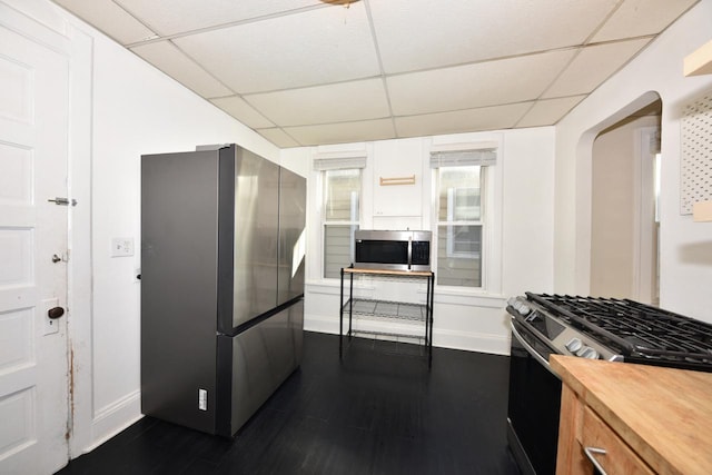 kitchen with a paneled ceiling, stainless steel appliances, and wooden counters