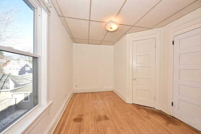 interior space featuring a drop ceiling and light wood-type flooring