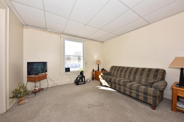 living room with a paneled ceiling and carpet