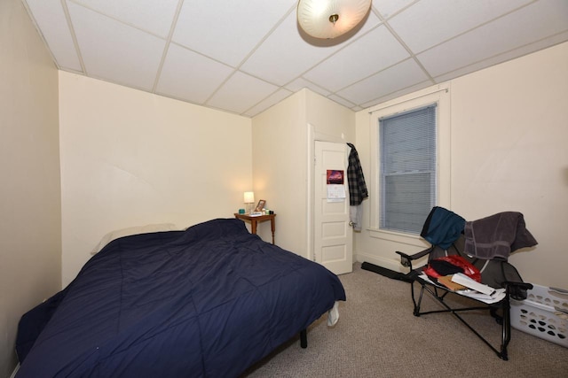 bedroom with light carpet and a drop ceiling