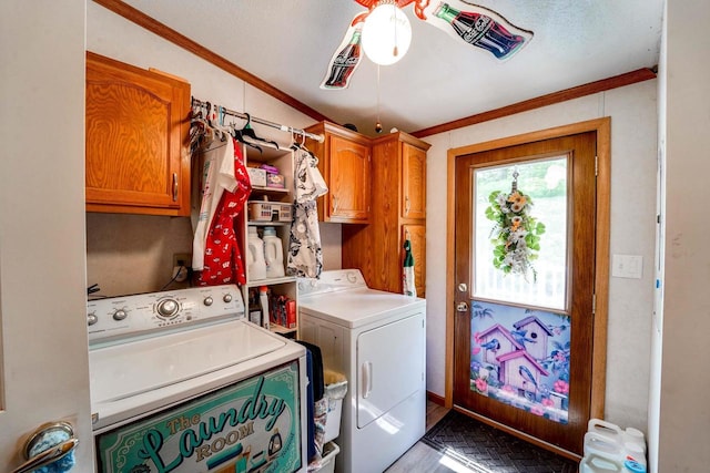 laundry area featuring washer and clothes dryer, cabinets, and crown molding