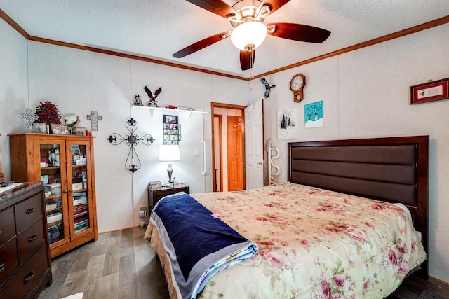 bedroom with ceiling fan, crown molding, wood-type flooring, and a textured ceiling