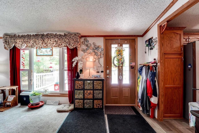 entryway featuring plenty of natural light, carpet floors, and a textured ceiling