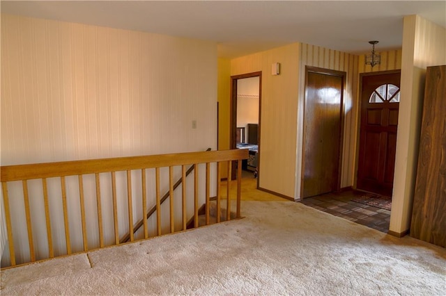 hallway featuring carpet flooring and an inviting chandelier