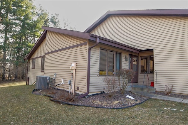 view of home's exterior with a lawn and central AC