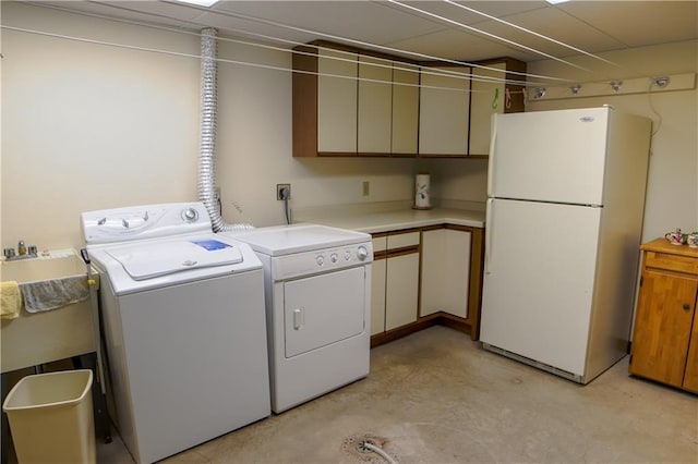 clothes washing area featuring washer and clothes dryer and cabinets