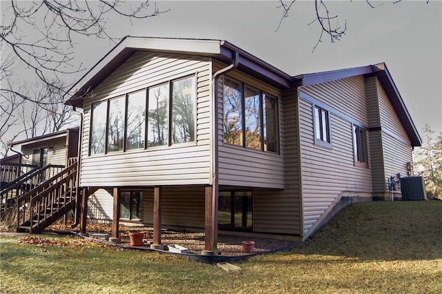 view of side of home featuring a yard and central AC