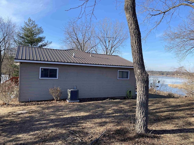 view of side of home with a water view and central AC