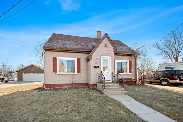 view of front facade featuring an outdoor structure, a front yard, and a garage