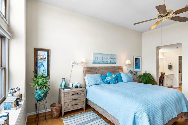 bedroom with multiple windows, hardwood / wood-style floors, ensuite bathroom, and ceiling fan