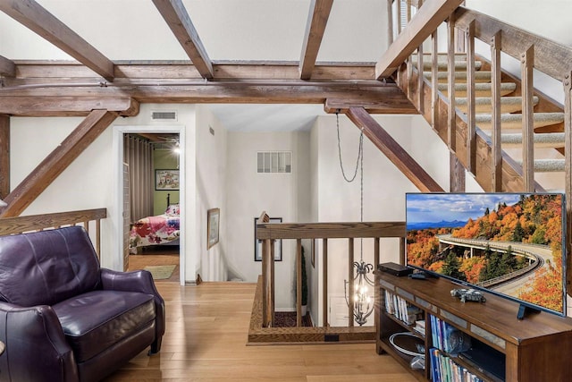 interior space with beam ceiling and light wood-type flooring