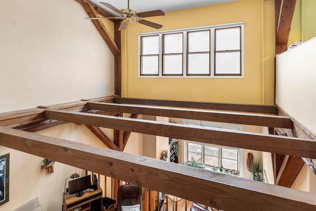 stairway featuring ceiling fan and beamed ceiling