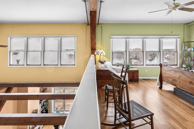 stairway with beam ceiling, ceiling fan, and wood-type flooring