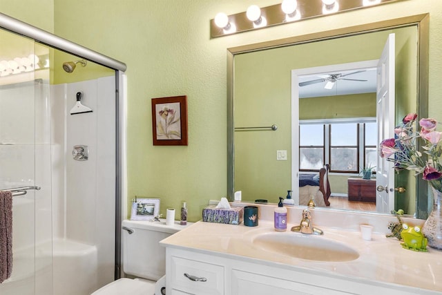 bathroom with vanity, ceiling fan, toilet, and walk in shower