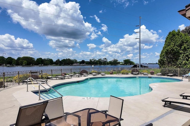 view of pool featuring a water view and a patio area