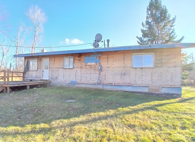 rear view of house with a yard and a deck