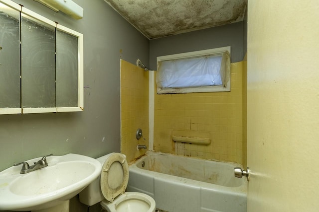 full bathroom featuring toilet, tiled shower / bath, and sink