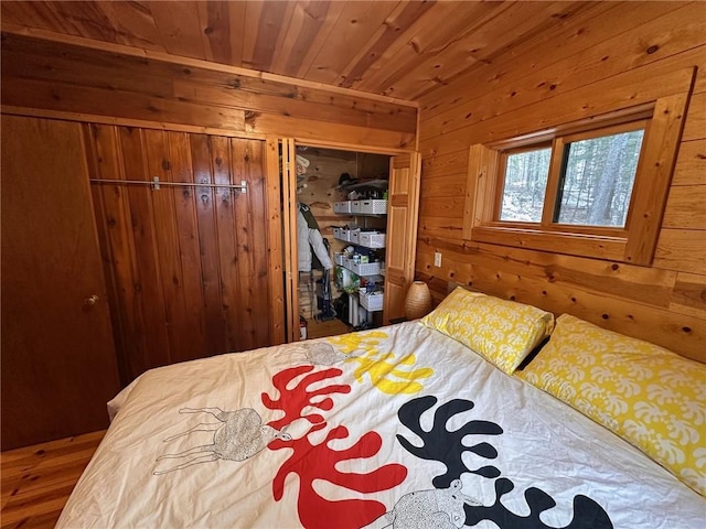 bedroom featuring wood walls, wood ceiling, and a closet