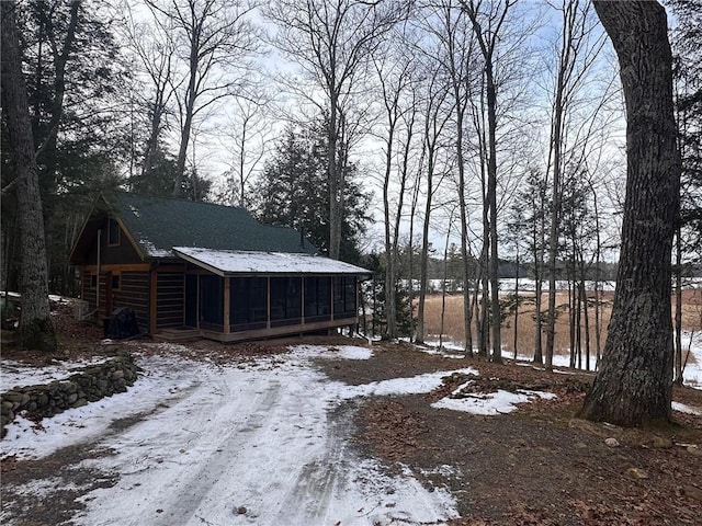 yard layered in snow featuring a sunroom