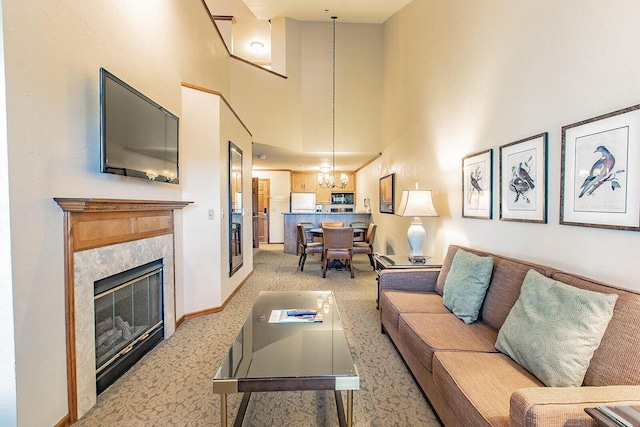 carpeted living room featuring a towering ceiling and an inviting chandelier