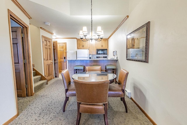 dining area with ornamental molding, light colored carpet, and a notable chandelier